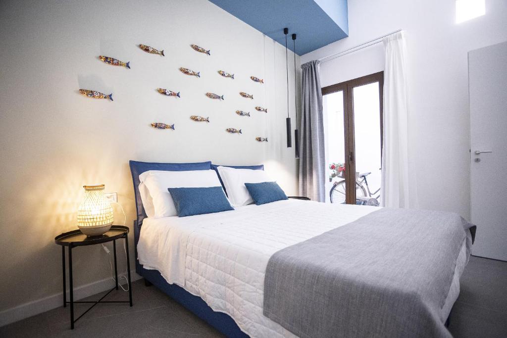 圣维托罗卡波Acquarò Suite Apartments的一间卧室配有一张带蓝色枕头的大床