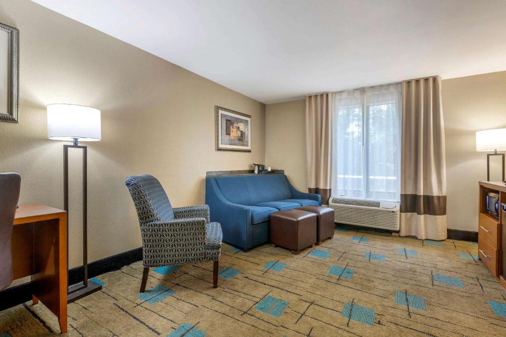 博福特Comfort Suites near MCAS Beaufort的客厅配有蓝色的沙发和椅子