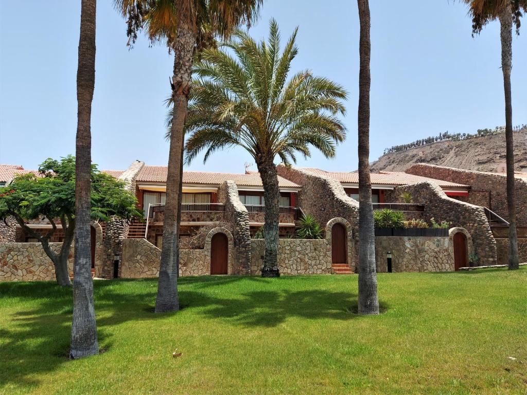 大加那利岛拉斯帕尔马斯Casa Tauro Golf - Luxury chalet with sea view的庭院里棕榈树的房子