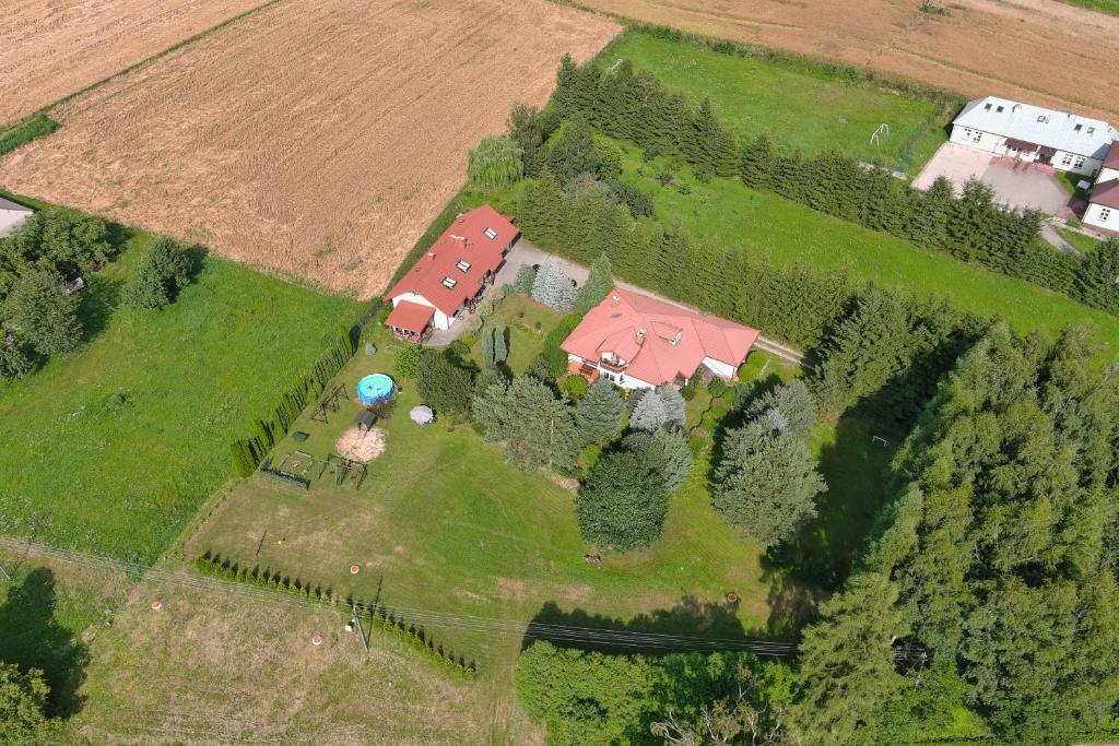 GrabkówŚwierkowe Wzgórze的享有农场的空中景色,拥有房子和树木