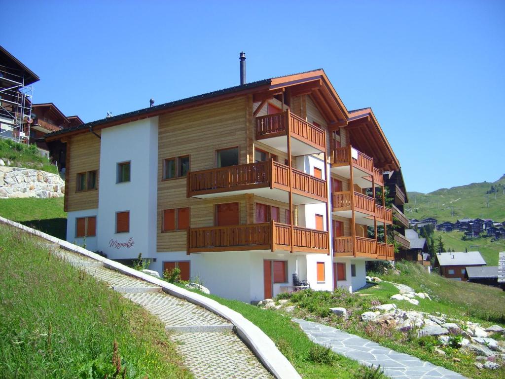 贝特默阿尔卑Lorli的山丘上带木制阳台的公寓楼