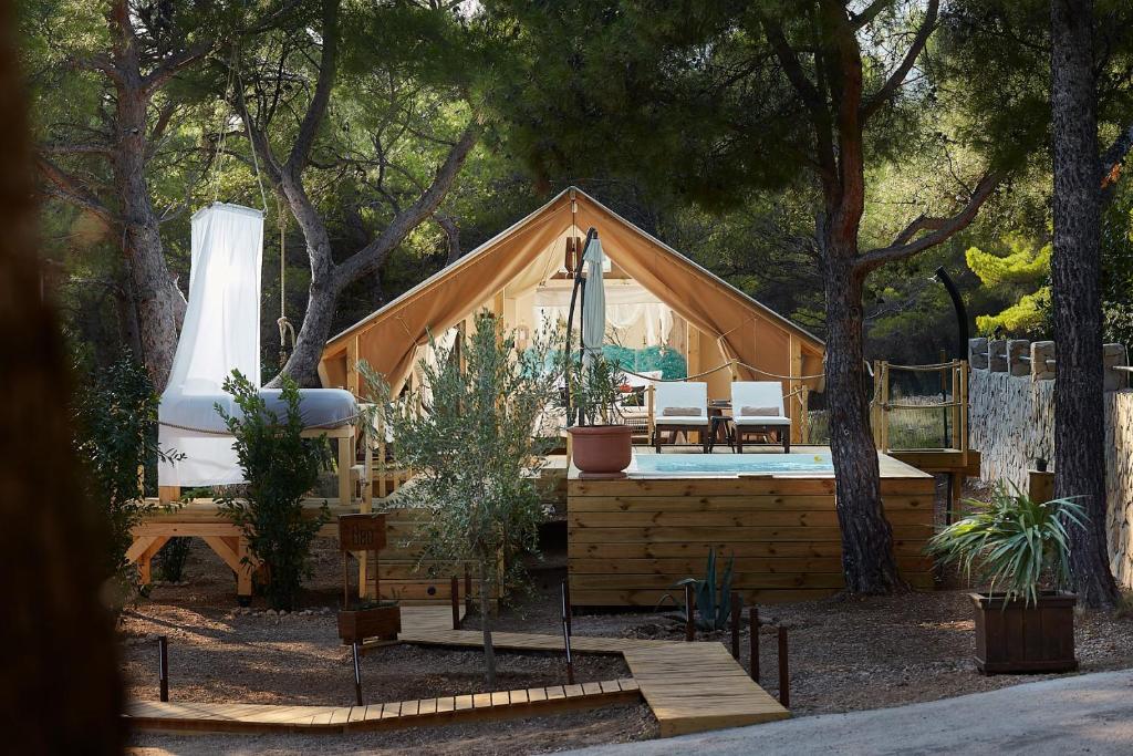 波尔Abeille Maison Glamping Resort Zlatni Rat -Adults Only的大型木屋,设有门廊和游泳池