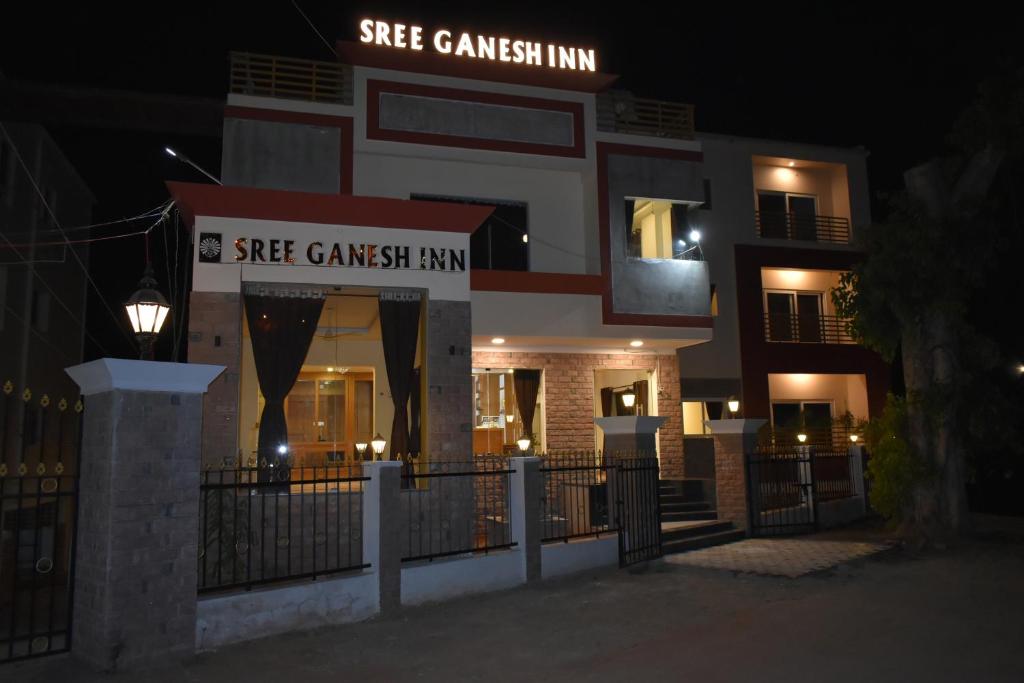 帕拉尼Sree Ganesh Inn的一座建筑,上面有标志,上面写着她高斯的旅馆