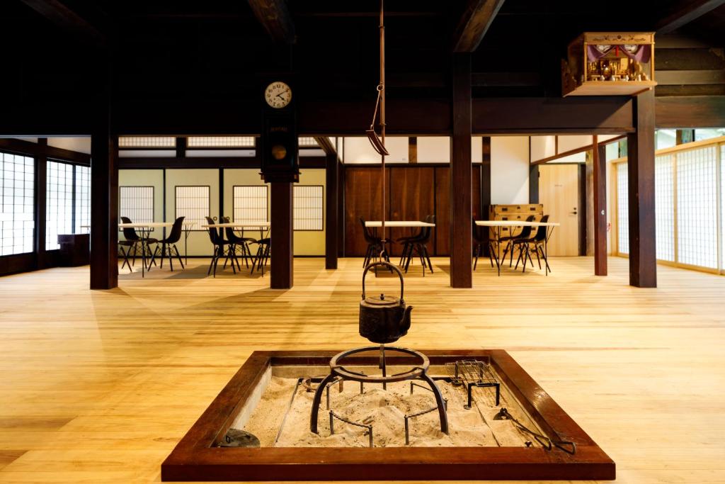 小松市Denpaku Komatsu的配有桌椅和时钟的房间