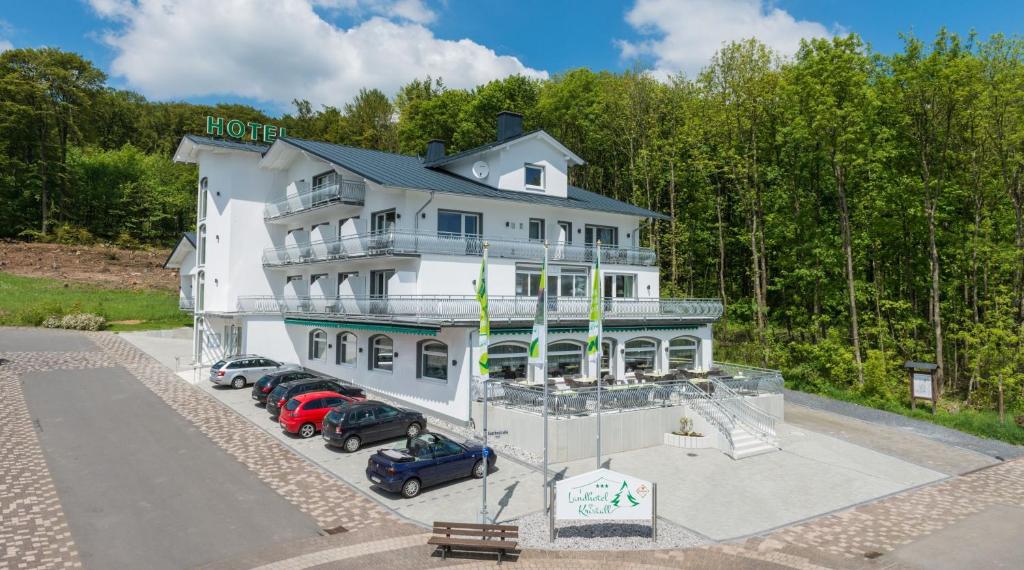 巴特马林贝格Landhotel Kristall的享有白色大建筑的空中景致,前面设有停车位