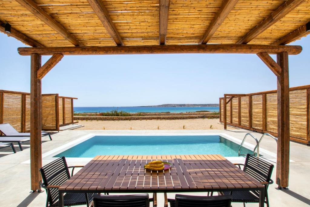 卡尔帕索斯Cato Agro 3, Seafront Villa with Private Pool的一个带桌椅的庭院和一个游泳池