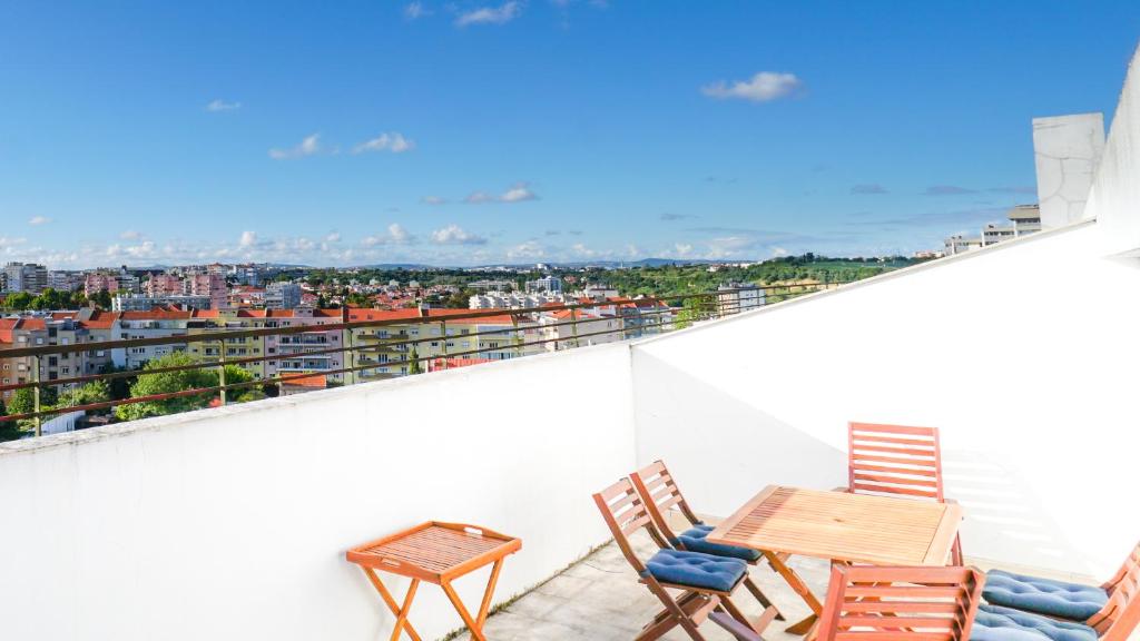 里斯本Lisbon Best Places - Rooftop的设有一个配有桌椅并享有美景的阳台。