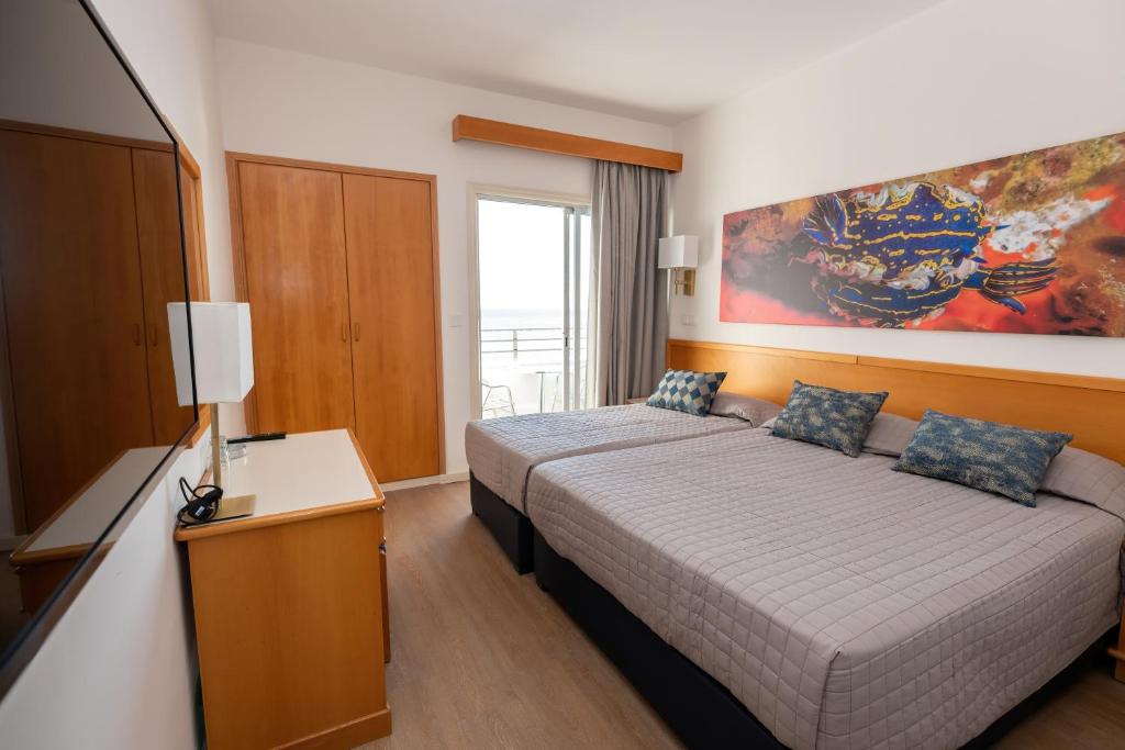 下皮尔戈斯提洛斯海滩酒店的酒店客房设有床和窗户。