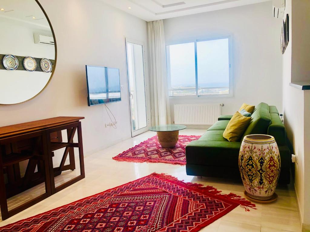 苏塞Byblos Sousse的客厅配有绿色沙发和镜子