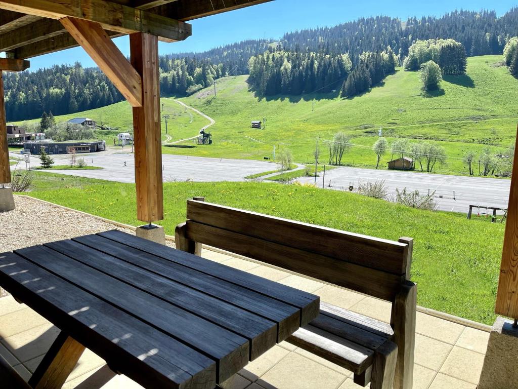 拉穆拉Gîte avec terrasse et belle vue - ChaletNelda com的门廊上的木凳,享有美景