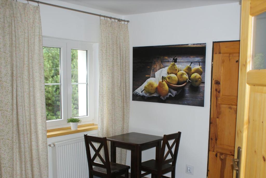 佩霍维采Karkonoski Sad的墙上有照片的房间里一张桌子和椅子
