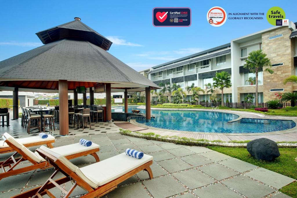 班贾尔马辛瑞雅婆罗洲马辰酒店的一个带凉亭和椅子的酒店和一个游泳池