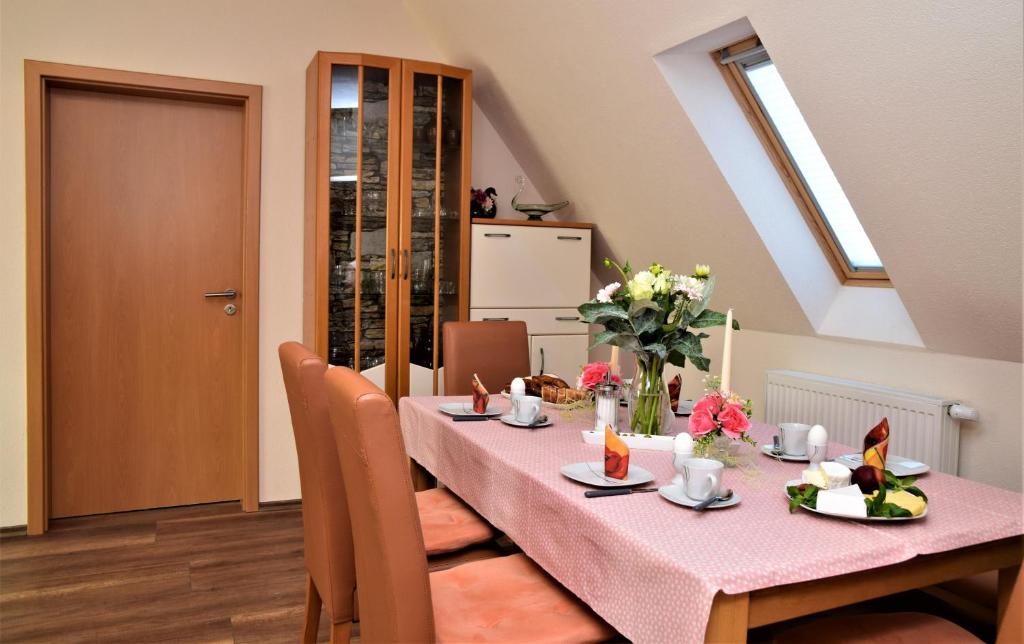 霍恩巴赫Ferienwohnung Anneliese am Stadttor的用餐室配有粉红色的桌子和鲜花