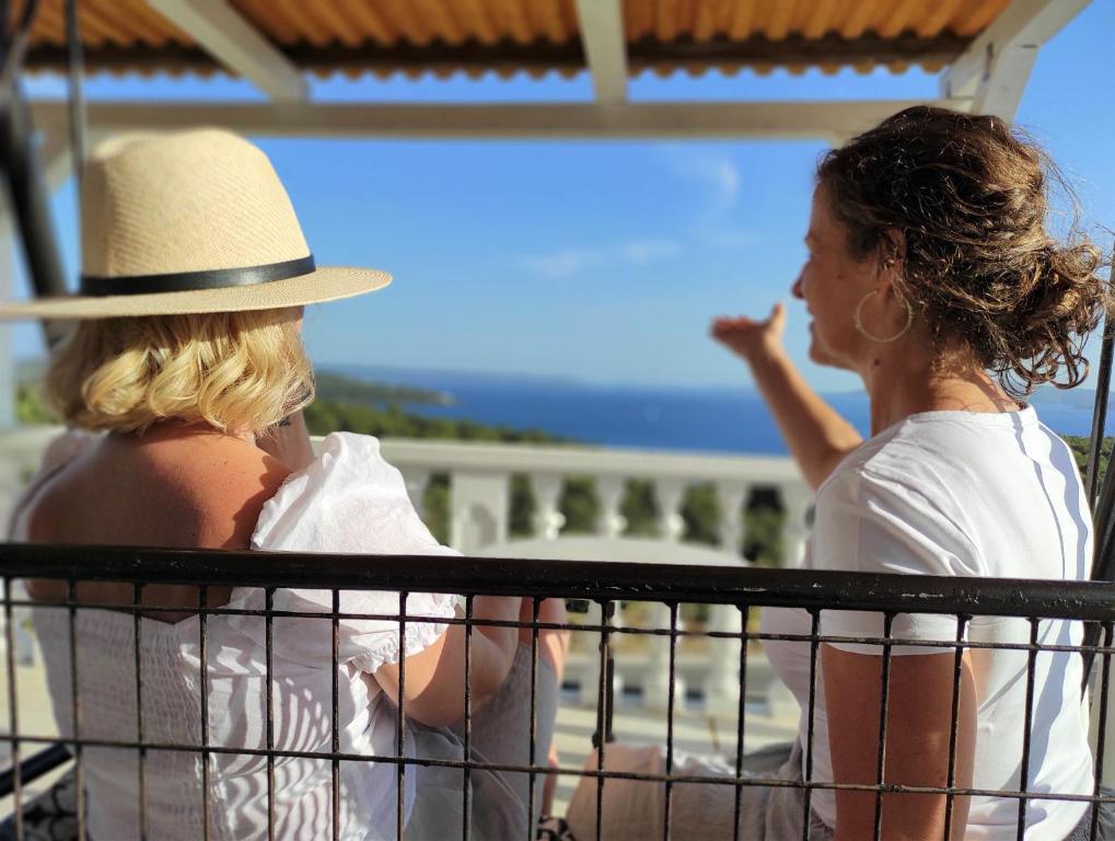 特罗吉尔Apartments Barisic Hrvatskih Žrtava 404 Seget Vranjica的两个女人从阳台上看海洋