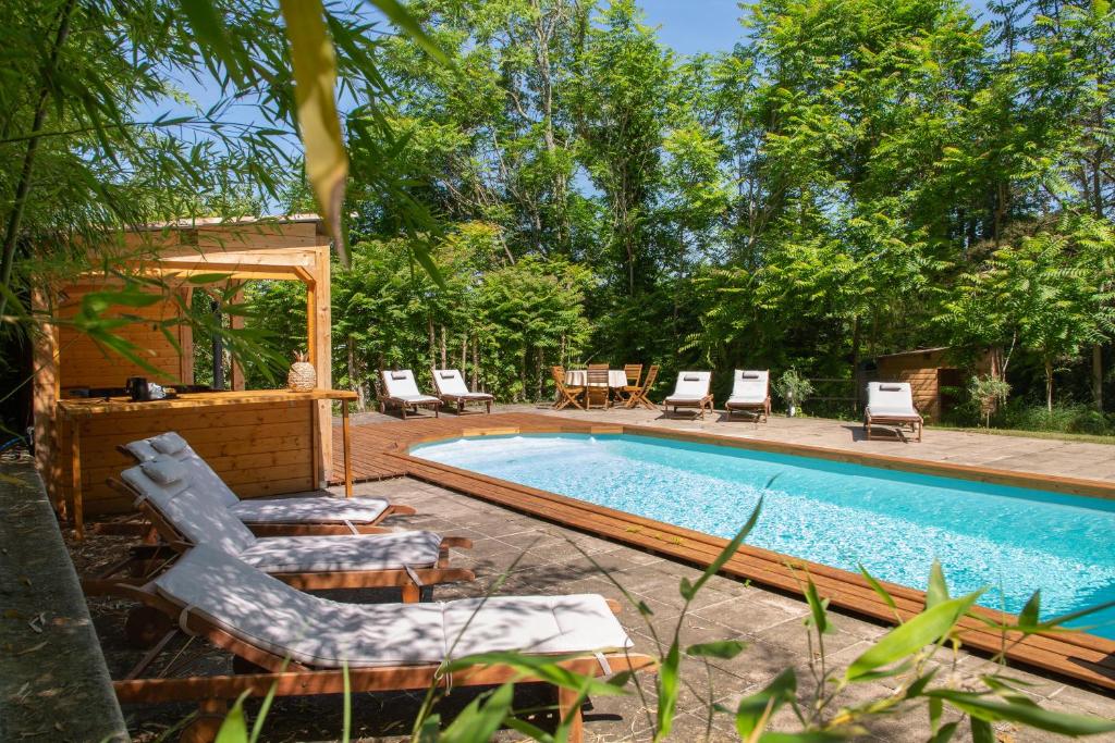 西埃勒河畔科尔德Chambre d'Hôtes Au Jardin Des Saveurs的一个带椅子和桌子的游泳池