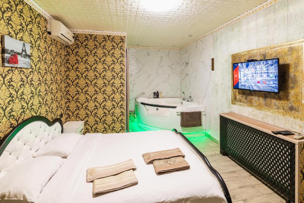第聂伯罗Смарт Апартаменты джакузи的卧室配有白色的床和水槽