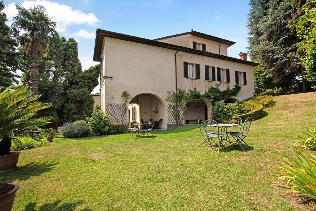 Annone di BrianzaVilla Giani的房屋设有庭院、椅子和桌子