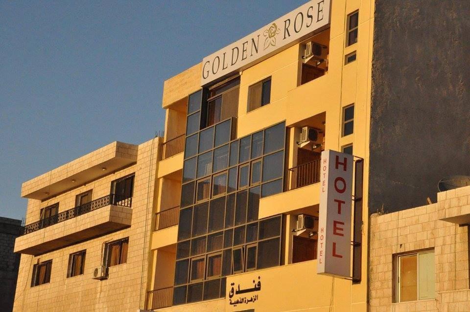 亚喀巴金玫瑰酒店的建筑的侧面有标志