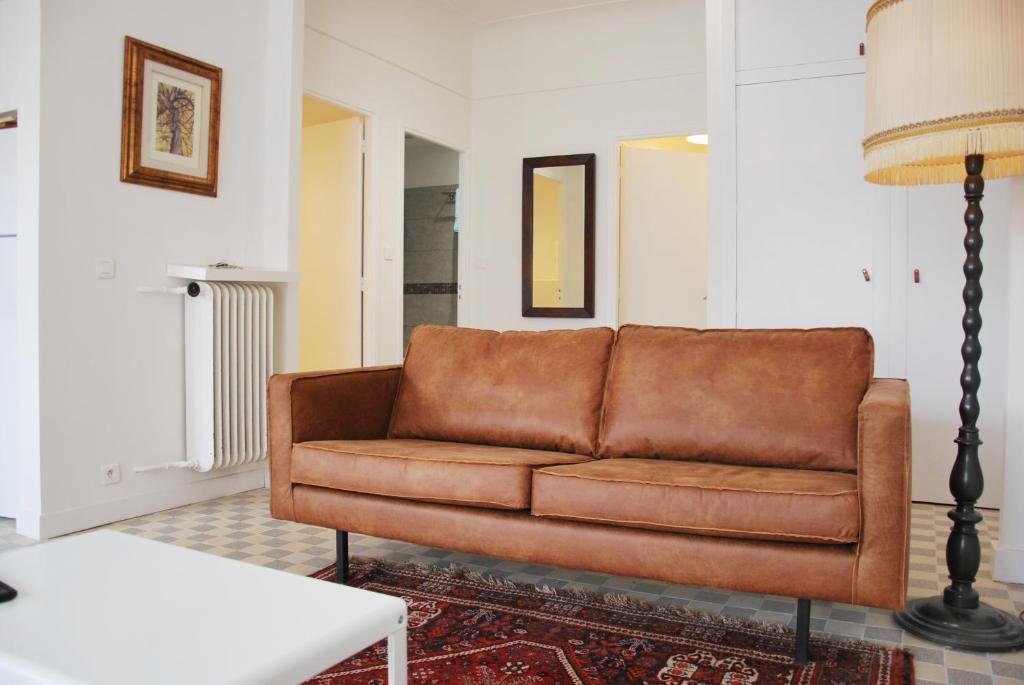 尼斯Les Gérardines by EnjoyNice, 3-room with Airco and balcony的客厅里一张棕色的皮沙发