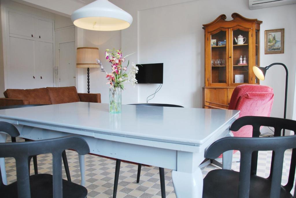 尼斯Les Gérardines by EnjoyNice, 3-room with Airco and balcony的白色的餐桌,配有椅子和花瓶