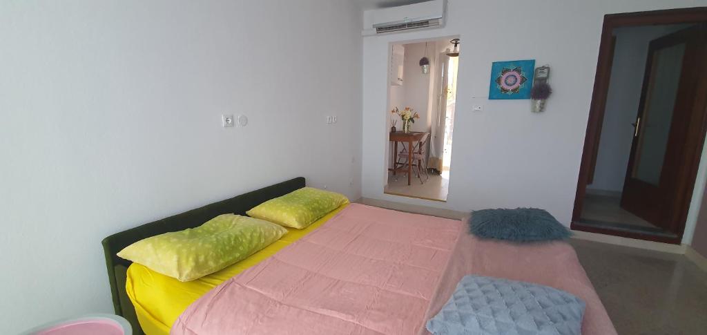 LokevApartma Jasna的一间卧室配有一张带黄色和绿色枕头的床