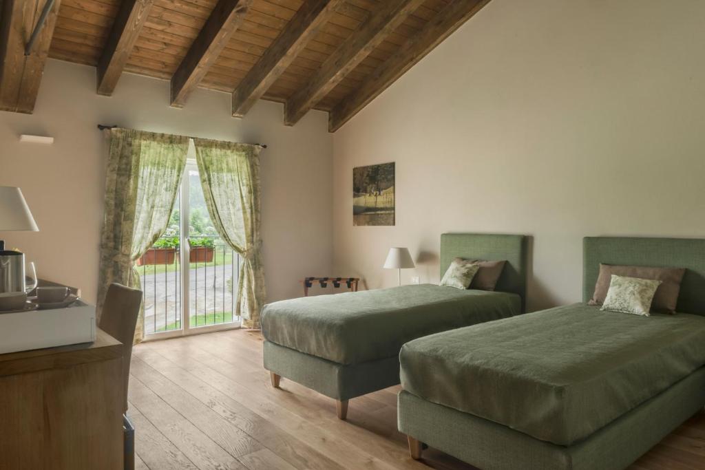  TassaroloFORESTERIA DEL GAVI的一间卧室设有两张床和窗户。