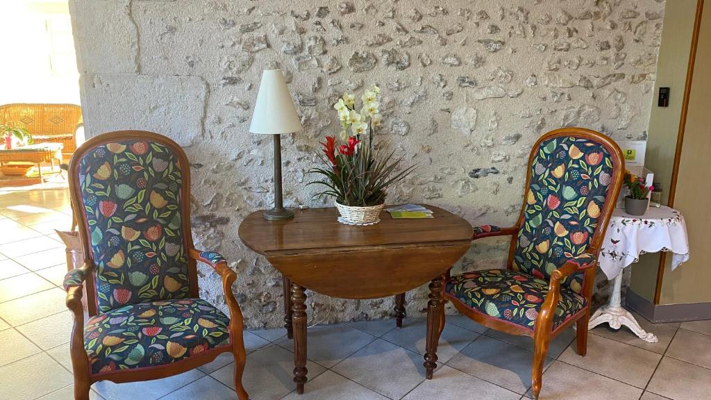 Bléneau布兰奇卡斯提尔酒店的一间设有桌子、两把椅子和一盏灯的房间