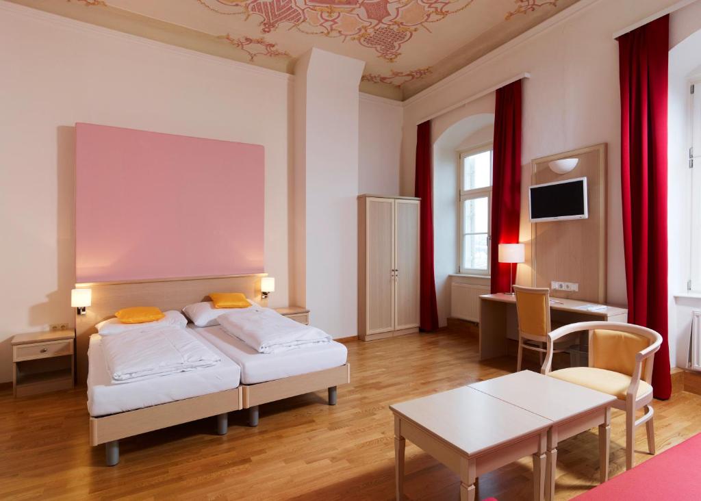 奥西阿赫CMA Stift Ossiach的酒店客房设有两张床和一张桌子。