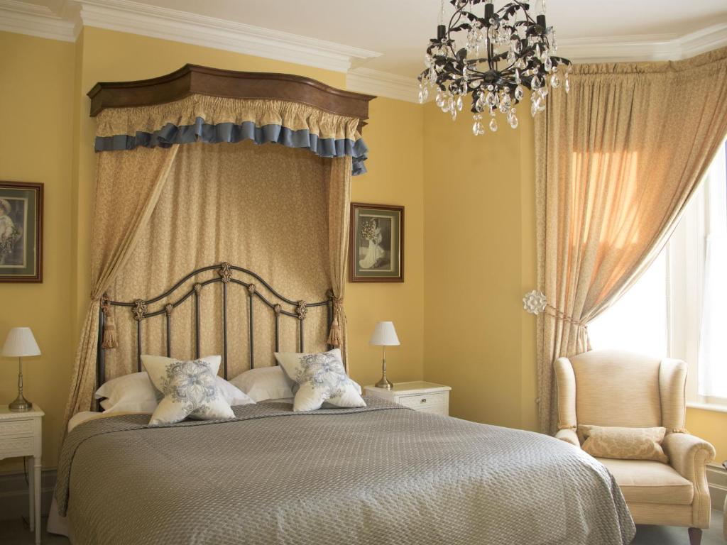伊斯特布恩Albert & Victoria Guest House的一间卧室配有一张大床和一个吊灯。