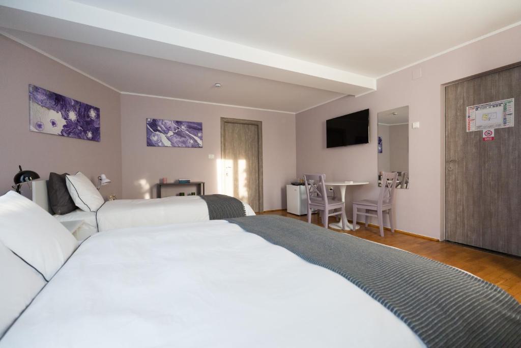 塔古玖Casa Ris的酒店客房设有一张白色大床和一张桌子。