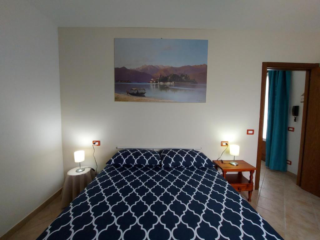 斯特雷萨La Casa delle Camelie的一间卧室配有一张蓝色的床和两盏灯。