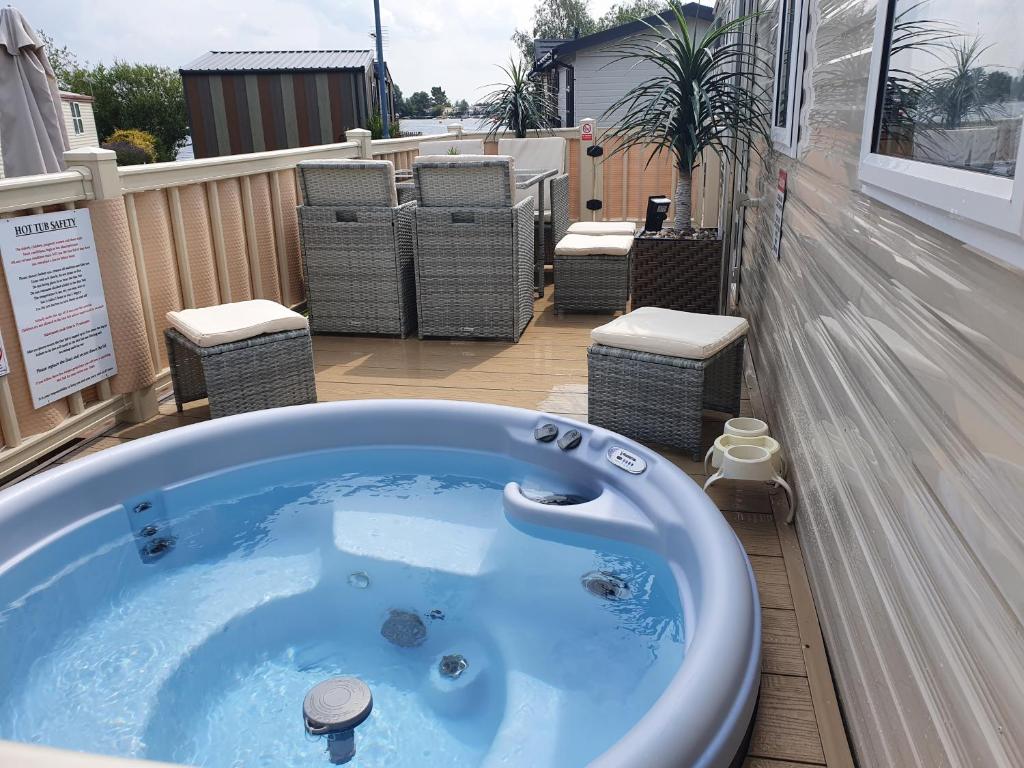 塔特舍尔Relaxing Breaks with Hot tub at Tattershal lakes 3 Bedroom的阳台设有按摩浴缸和椅子