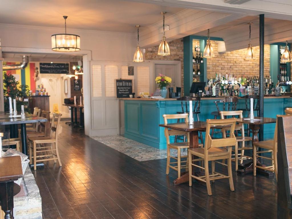 伦敦绿色W7酒店的一间带桌椅的餐厅和一间酒吧