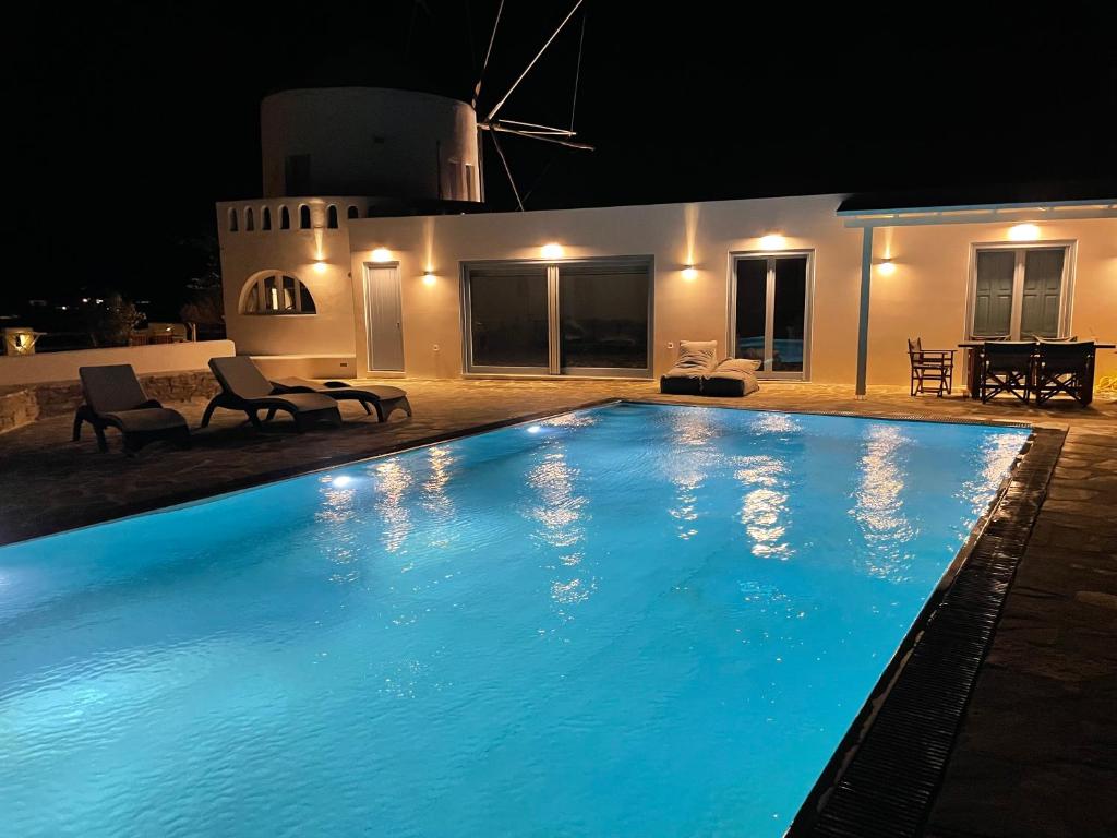 SorosWindmill House Antiparos的夜间大型蓝色游泳池