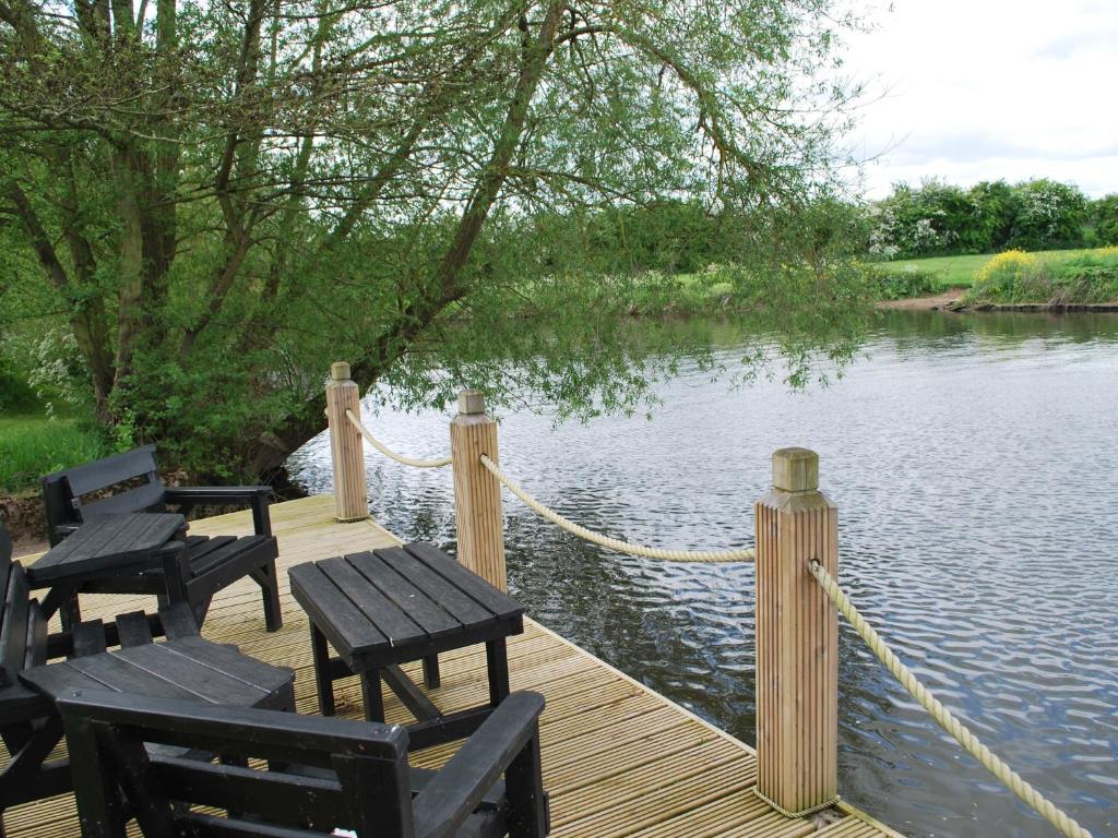 埃文河畔斯特拉特福水边宾馆的水面上设有野餐桌和椅子的码头