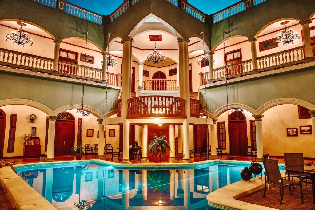 格拉纳达雷亚尔梅赛德酒店的一座带房子的建筑中的室内游泳池