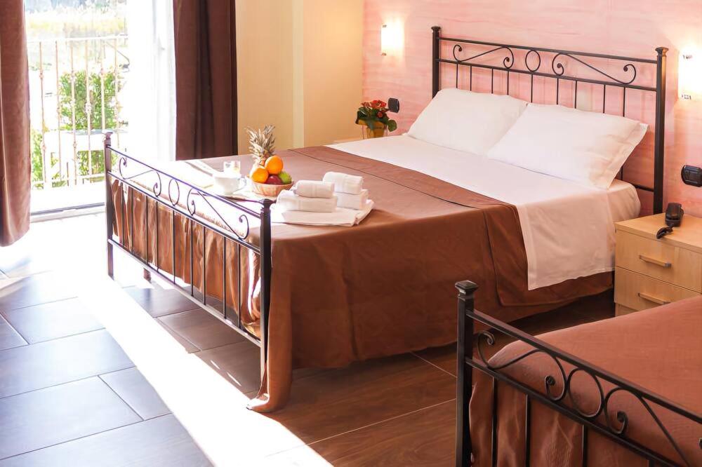 利卡塔Mimí Hotel的一间带大床的卧室和一个阳台