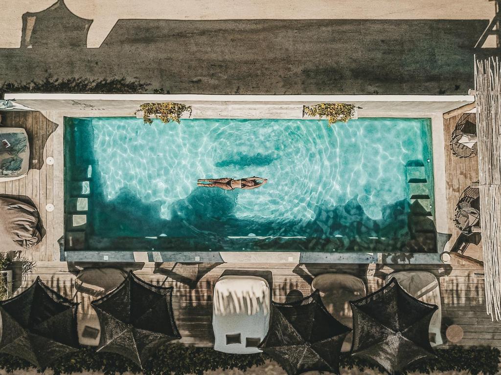 奥尔沃克斯岛Boutique Hotel EL NIDO Holbox的游泳池的画画,里面装有一条船