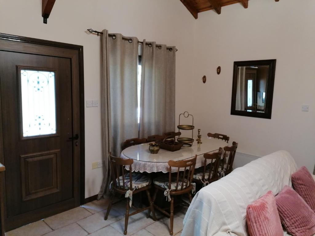 KhandriaHouse de Fountas的一间带桌椅和窗户的用餐室