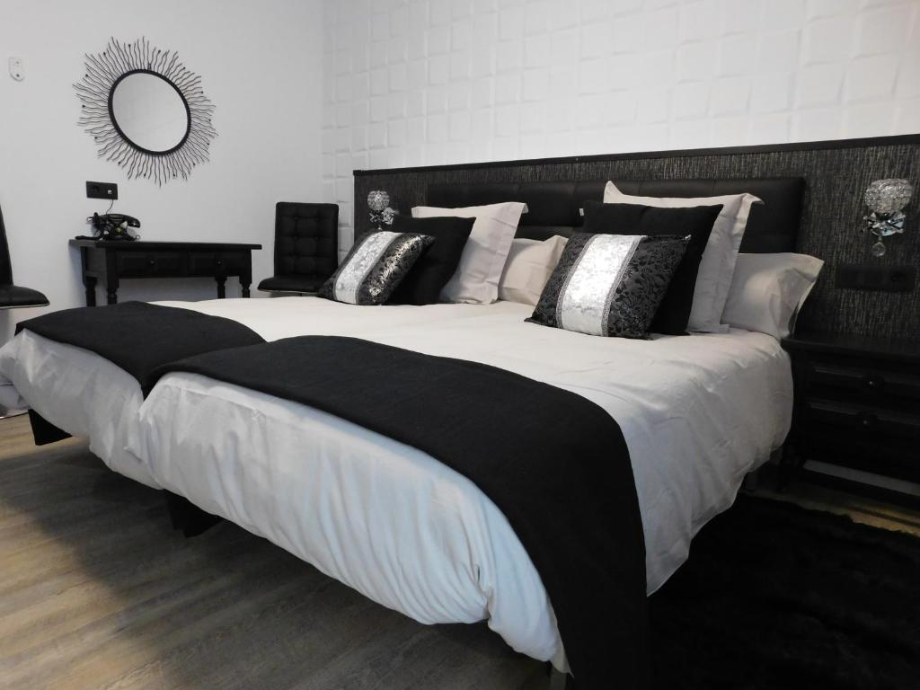 蒙福特·德·莱蒙斯HOTEL TERRA GALEGA MEIGA的一张大床,上面有黑白枕头