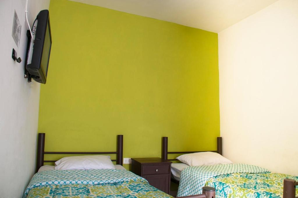 奥夫雷贡城Hotel Bugambilias的一间设有两张床和黄色墙壁的客房