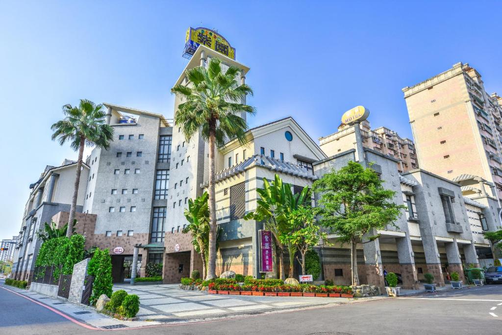 高雄紫园汽车旅馆 的街道前方有棕榈树的建筑