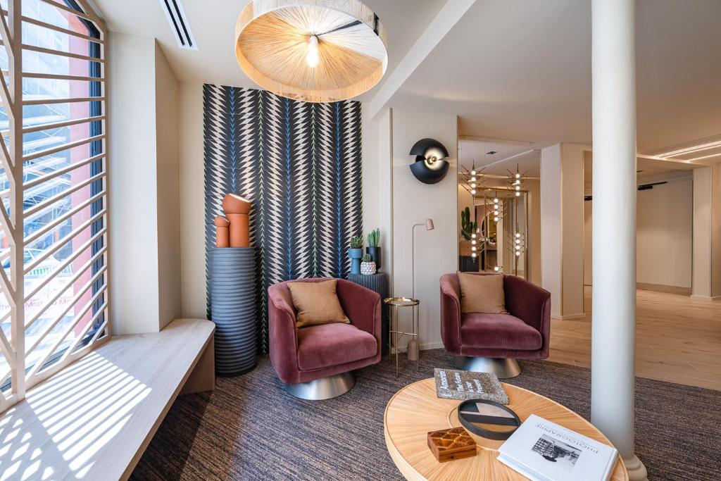 巴黎O.Lysée Hotel的客厅配有两把椅子和一张桌子