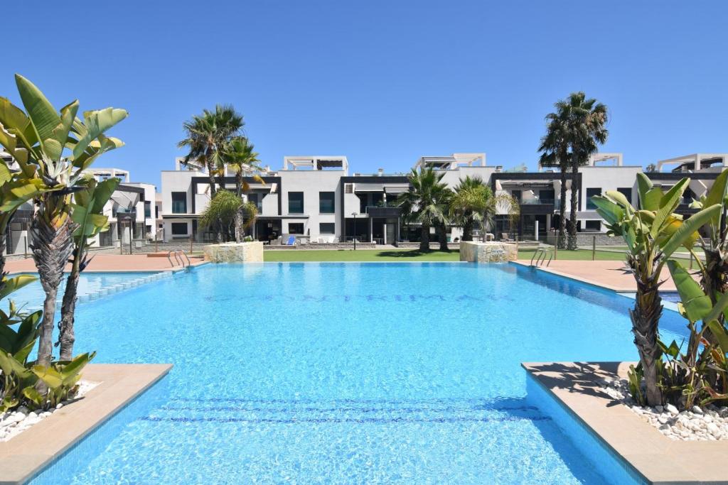 奥里韦拉Oasis Beach的一座棕榈树和建筑的大型游泳池