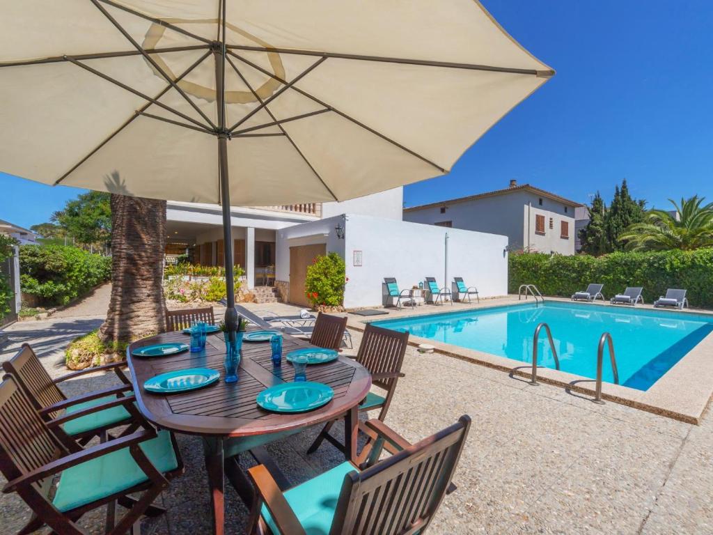 坎帕斯蒂利亚Villa antonio的游泳池旁带遮阳伞的桌子
