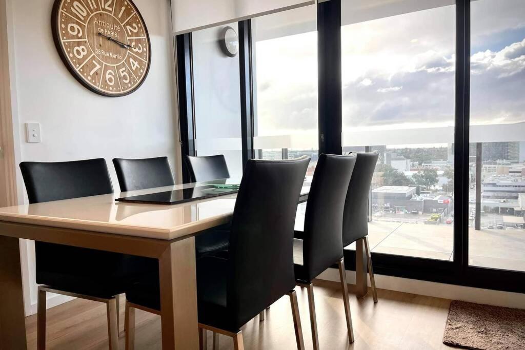 阿德莱德Enjoy a little Luxury in Adelaide CBD - Perfect!的餐桌、椅子和墙上的时钟