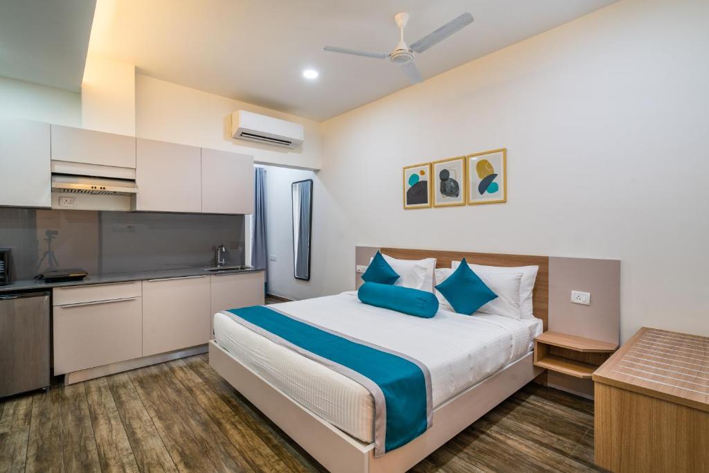 海得拉巴SKYLA Serviced Apartments & Suites, Hi-Tech City的一间带大床的卧室和一间厨房