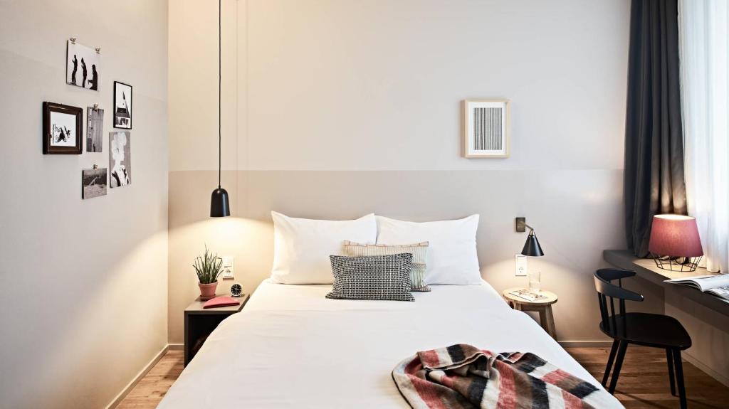 慕尼黑Bold Hotel München Giesing的卧室配有一张大白色的床和书桌