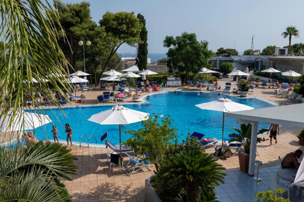 圣凯撒利亚温泉圣塔露西亚酒店的一座大型游泳池,里面设有椅子和遮阳伞