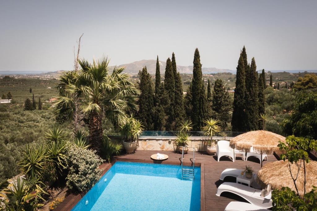 MouzákionArk Luxury & Private Villa的度假村的游泳池,带椅子和树木